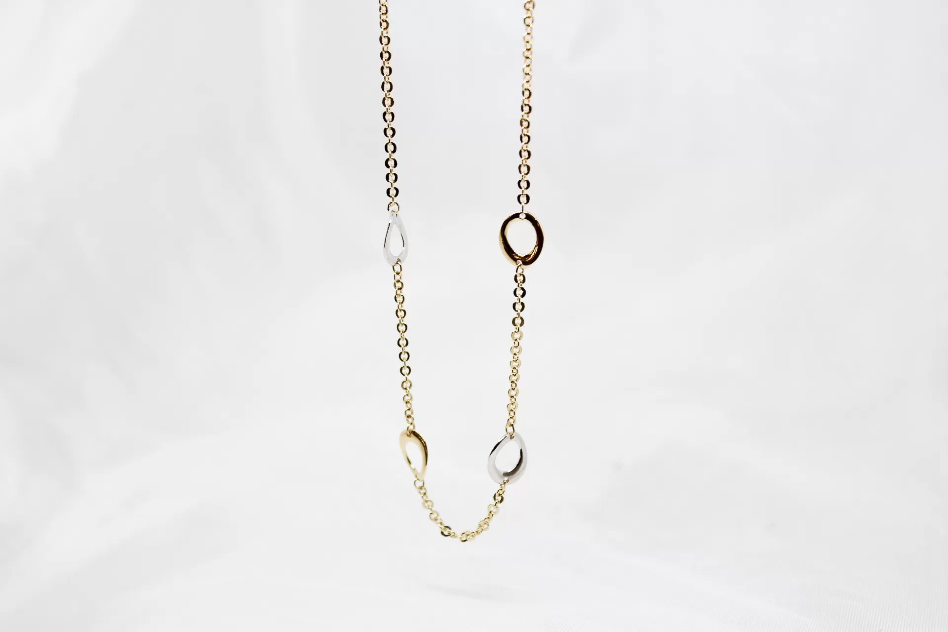 Colar em ouro bicolor, com argolas no centro