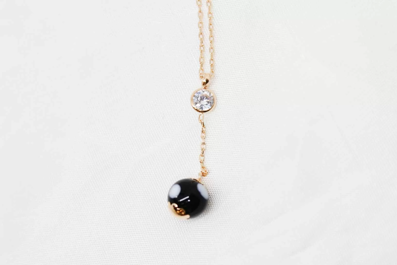 Colar em ouro com bola preta e zircónia